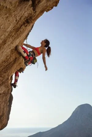 outdoor rock climbing for beginners | young woman is rock climbing outdoors